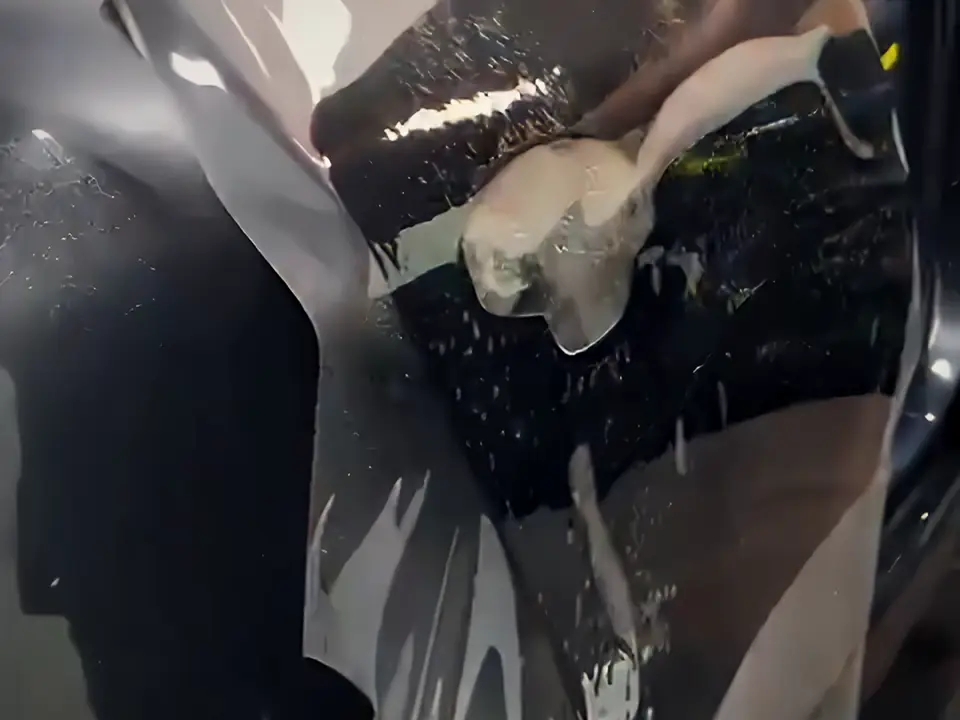 فني يركّب فيلم حماية PPF شفاف على سيارة